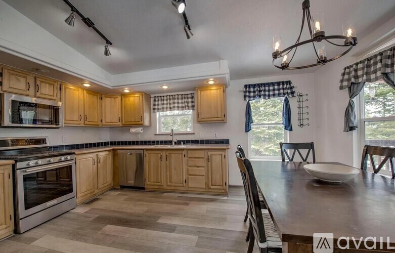 A kitchen with wooden cabinets and a checkered curtain.