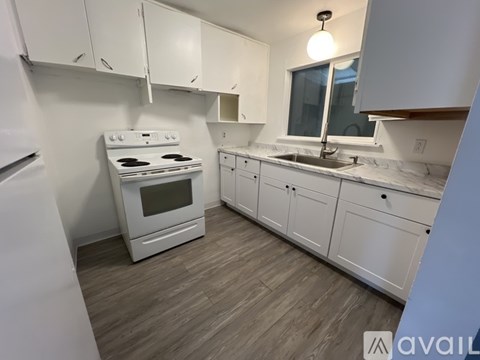 A kitchen with white appliances and cabinets.