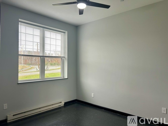 A room with a window and a ceiling fan.