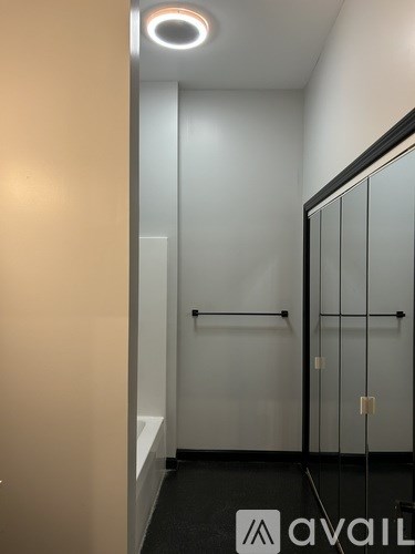 A hallway with a glass door and a black and white logo on the floor.