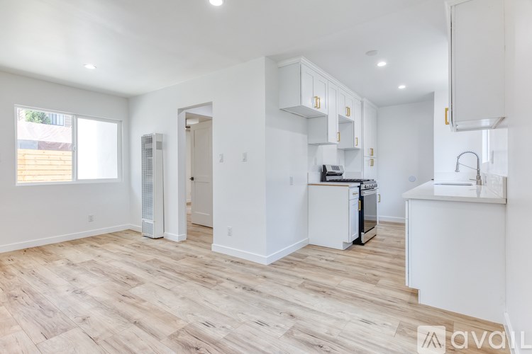 A kitchen with white cabinets and a wooden floor.