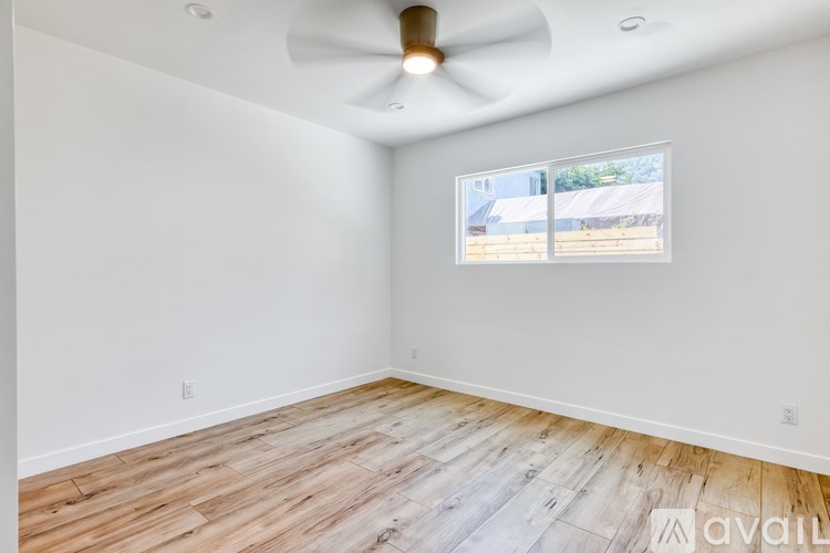 A room with a ceiling fan and a window with blinds.
