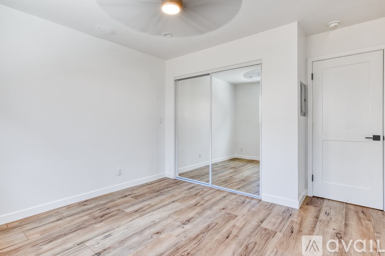 A room with a white door and a mirror on the wall.