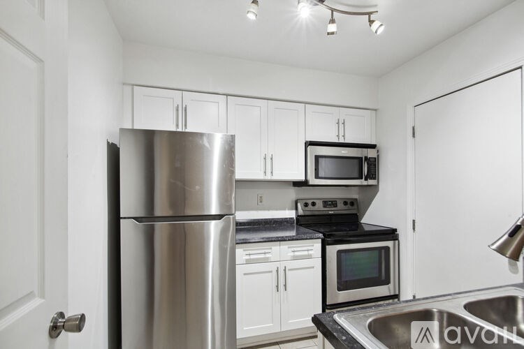 A kitchen with a stainless steel refrigerator, microwave, oven, and sink.