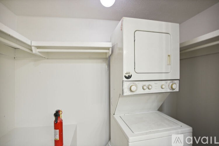A white oven with a fire extinguisher on the floor.