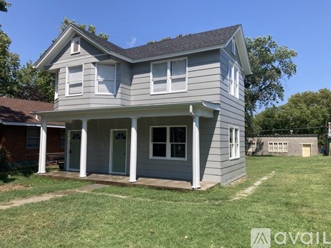 A two-story house with a porch and a garage door.