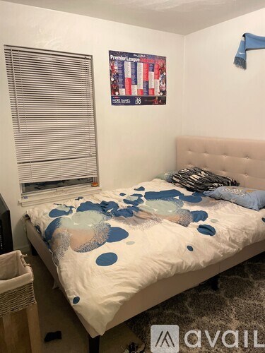 A bedroom with a bed covered in blue and white polka dots.