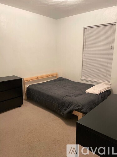 A bedroom with a bed, desk, and chair.