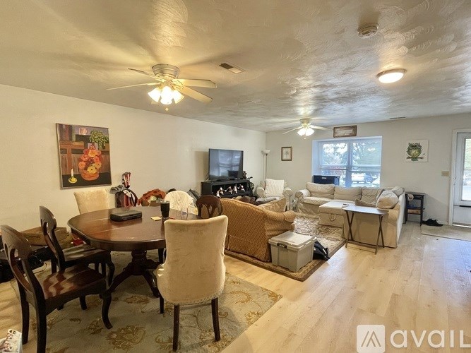 A living room with a dining table and chairs.