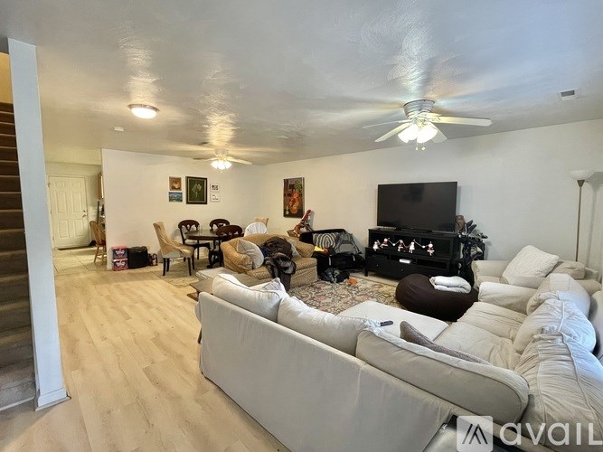 A living room with a white couch and a flat screen TV.