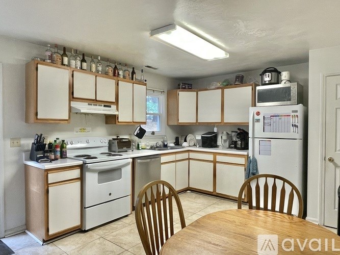 A kitchen with a table and chairs in front of it.