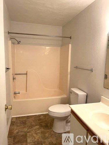 A bathroom with a toilet, sink, and bathtub.