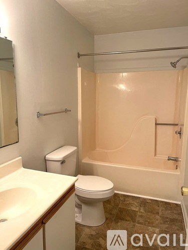 A bathroom with a toilet, sink, and bathtub.
