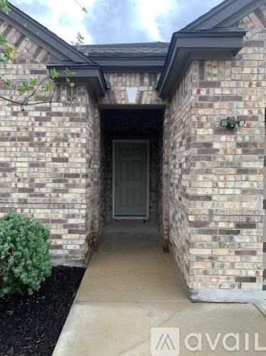 A house entrance with a glass door and a brick wall.