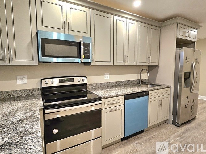 A kitchen with a stove, microwave, and refrigerator.