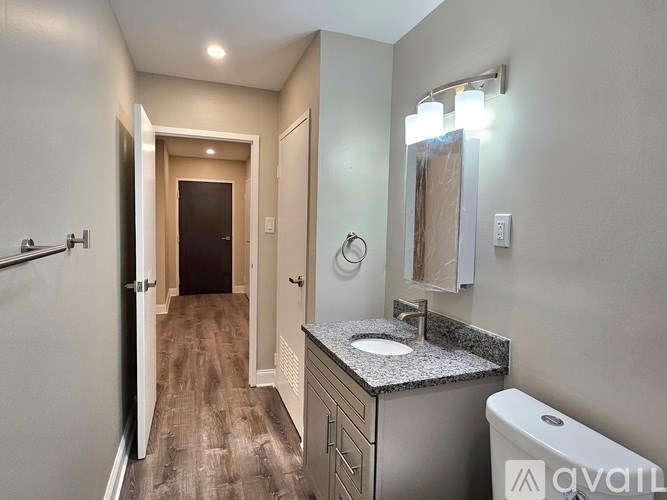 A bathroom with a sink, mirror, and toilet.