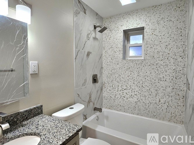 A bathroom with a marble countertop and a bathtub.