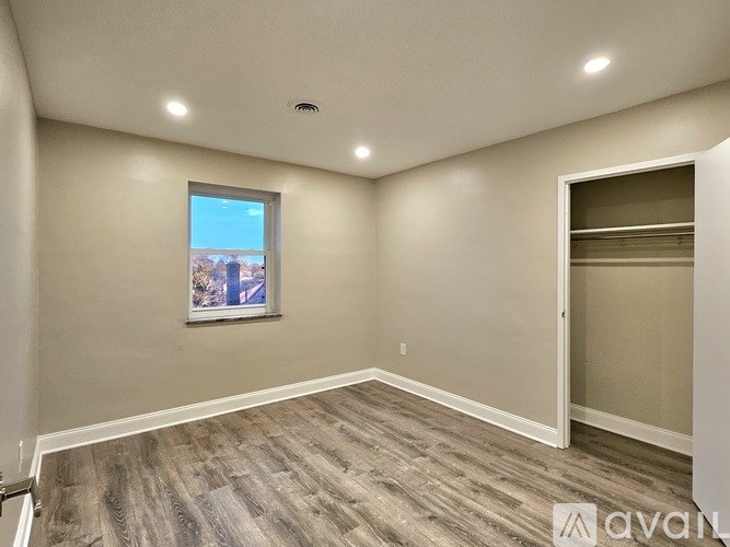 A room with a window and a picture on the wall.