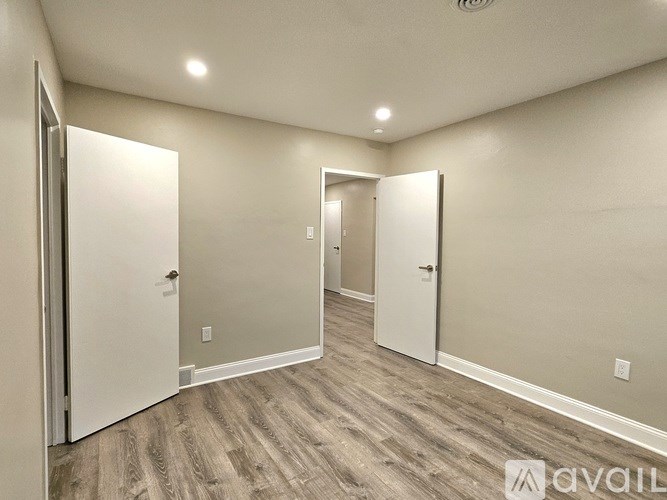 A room with two doors and a wooden floor.