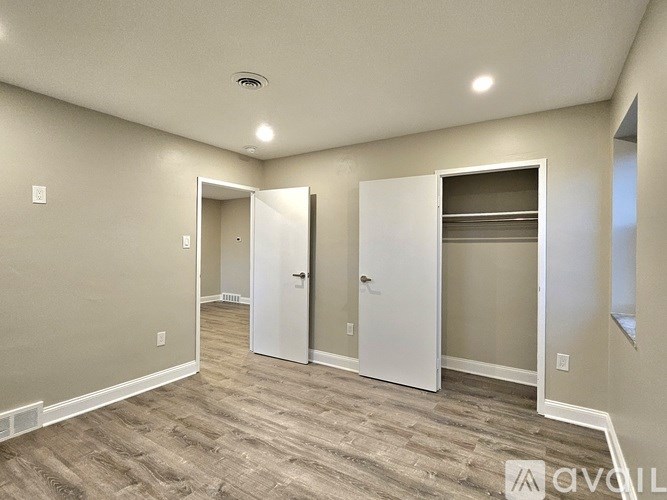 A room with a white door and a white cabinet with a shelf.