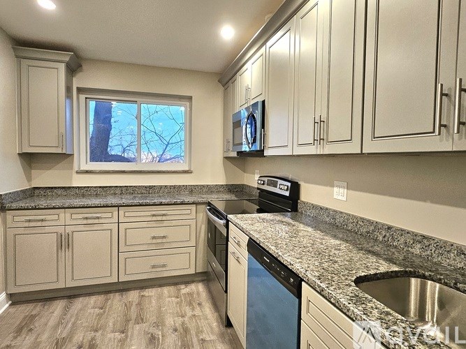 A kitchen with a granite countertop and stainless steel appliances.