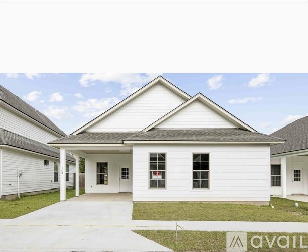 A white house with a grey roof is available for sale.