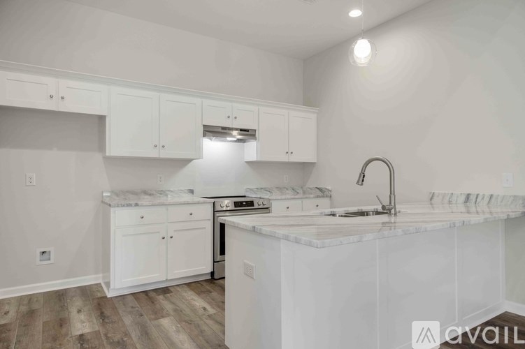 A kitchen with white cabinets and a marble countertop.