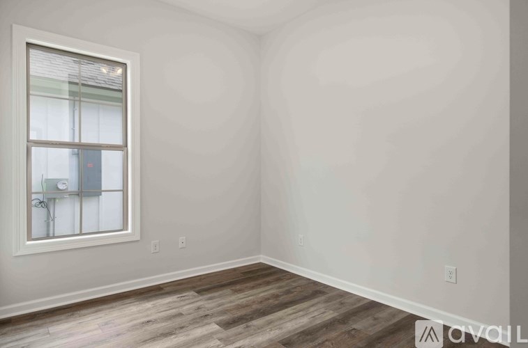 A room with a window and wooden flooring.