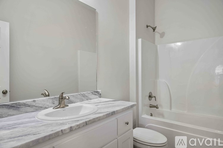 A bathroom with a marble countertop and a white toilet.