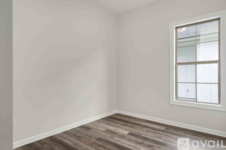 A room with a window and wooden flooring.