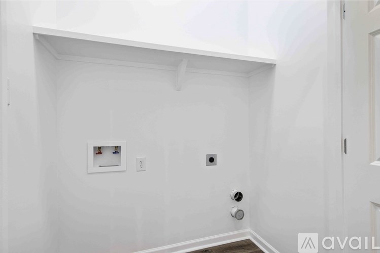A white wall with a picture frame and two switches.