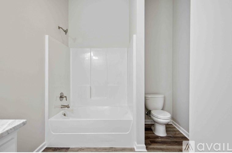 A white bathroom with a tub, toilet and sink.