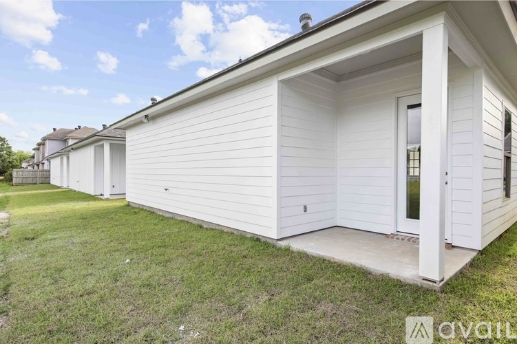 A white house with a brown roof and a glass door is for sale.
