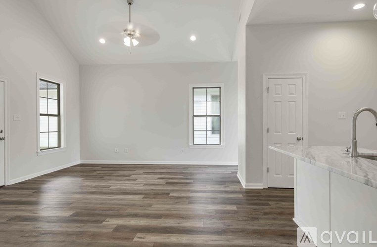 A spacious room with wooden flooring and a white countertop.