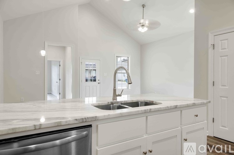 A kitchen with a marble countertop and a dishwasher.