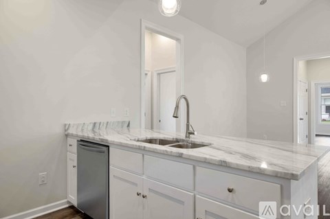 A kitchen with white cabinets and a marble countertop.