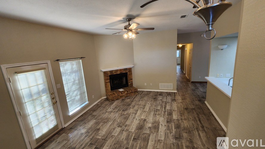 A living room with a fireplace and a fan.