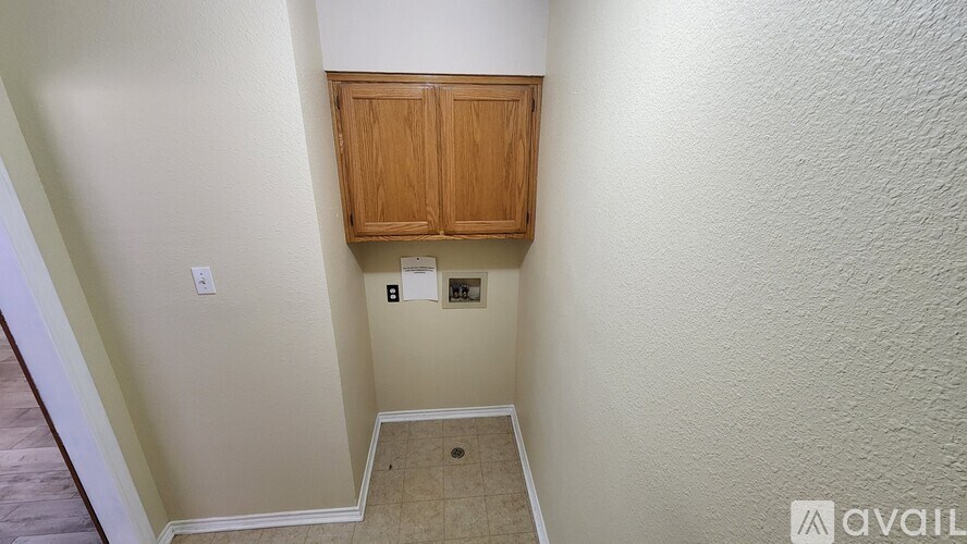 A small room with a wooden cabinet and a light switch.