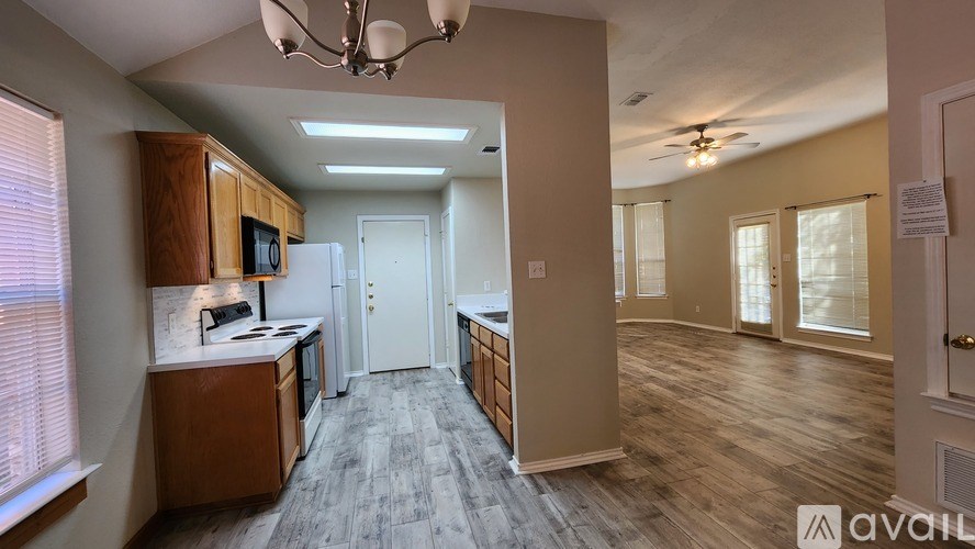 A kitchen with wooden cabinets and a refrigerator is available for rent.