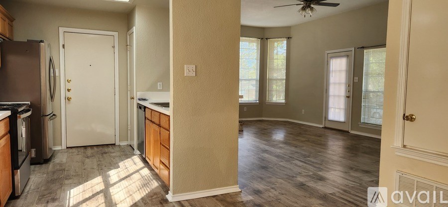 A kitchen with a refrigerator, sink, and cabinets.
