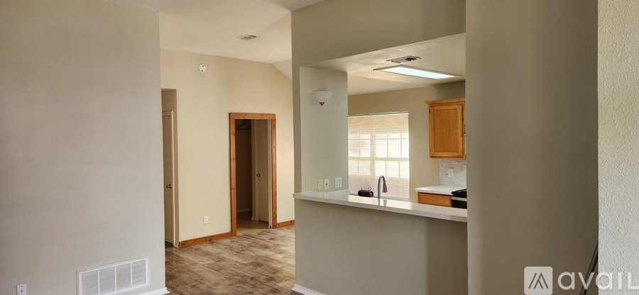 A room with a kitchenette and a door leading to another room.