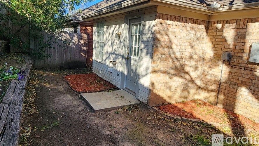 A backyard with a shed and a wooden fence.