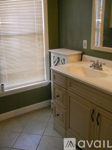 A bathroom with a sink, mirror, and cabinets.