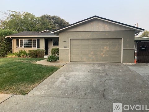 A house with a garage and a driveway in front.