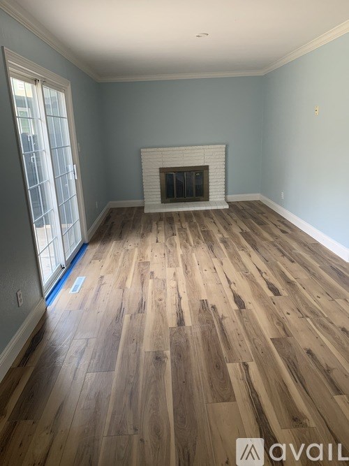 A room with a fireplace and wooden flooring.
