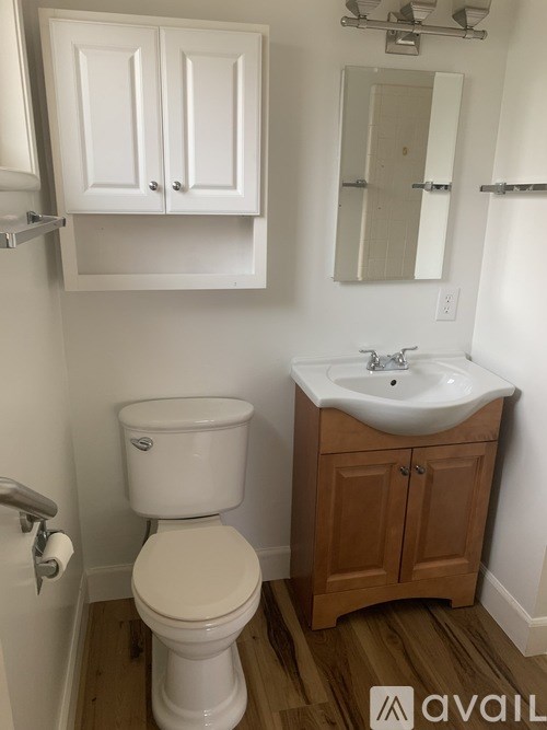 A white toilet sits next to a sink in a small bathroom.