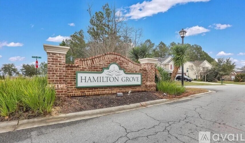 A sign that says "Hamilton Grove" is in front of a street.