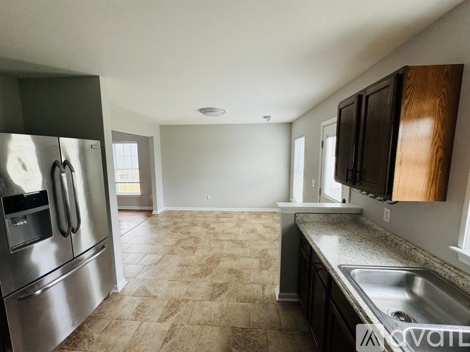 A kitchen with a stainless steel refrigerator and a sink.