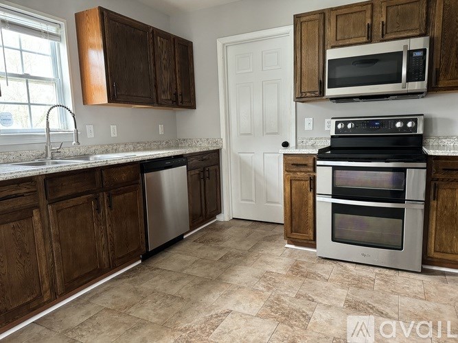 A kitchen with wooden cabinets and a tile floor.