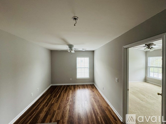 A room with wooden floors and a ceiling fan.